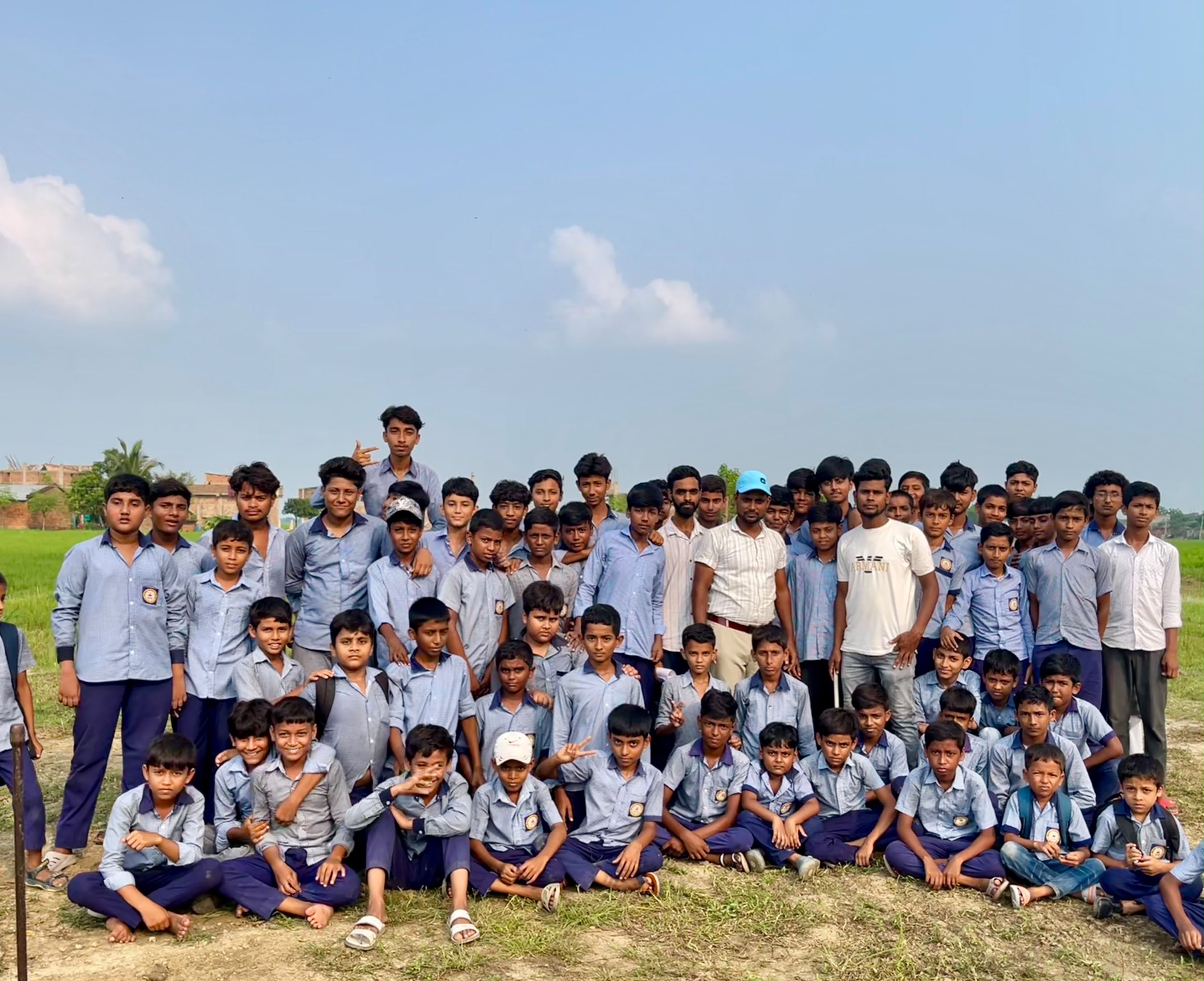 Students in school uniform with their teachers on the school field